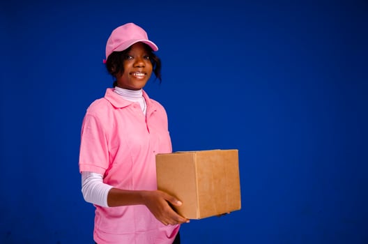 beautiful young african female courier worker holding a box photo