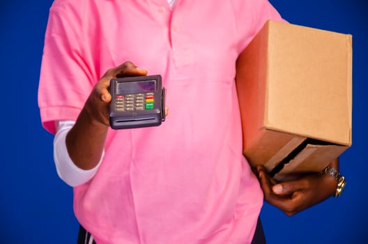 delivery worker holding a point of sale device photo