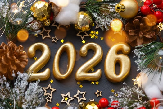 The golden figures 2026 made of candles on a black stone slate background are decorated with a festive decor of stars, sequins, fir branches, balls and garlands. Greeting card, happy New Year. photo