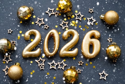 The golden figures 2026 made of candles on a black stone slate background are decorated with a festive decor of stars, sequins, fir branches, balls and garlands. Greeting card, happy New Year. photo