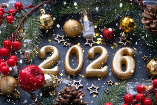 The golden figures 2026 made of candles on a black stone slate background are decorated with a festive decor of stars, sequins, fir branches, balls and garlands. Greeting card, happy New Year. photo