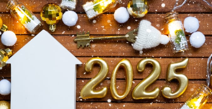 House key with tiny figure of home mock up on festive brown wooden background, lights of garlands. New Year 2025 wooden letters, greeting card. Purchase, construction, relocation, mortgage, insurance photo