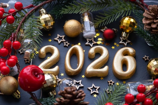 The golden figures 2026 made of candles on a black stone slate background are decorated with a festive decor of stars, sequins, fir branches, balls and garlands. Greeting card, happy New Year. photo