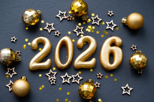 The golden figures 2026 made of candles on a black stone slate background are decorated with a festive decor of stars, sequins, fir branches, balls and garlands. Greeting card, happy New Year. photo