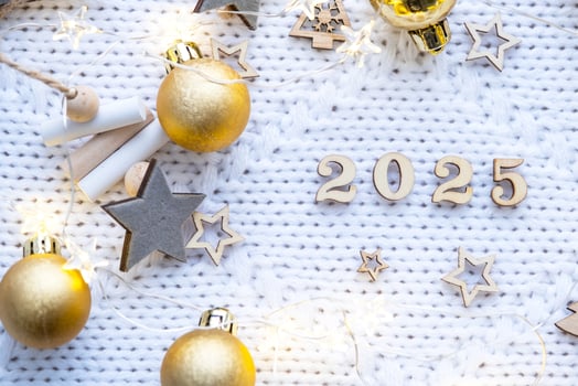 Happy New Year wooden numbers 2025 on cozy festive white knitted background with sequins, stars, lights of garlands. Greetings, postcard. Calendar, cover photo