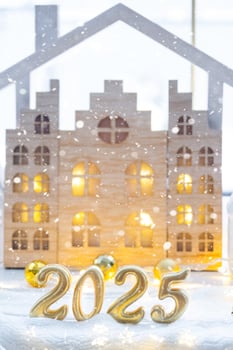 Golden figures number 2025 against the background of cozy windows of a house with warm light with festive decor of stars,snow and garlands. Greeting card, Happy New Year, cozy home photo