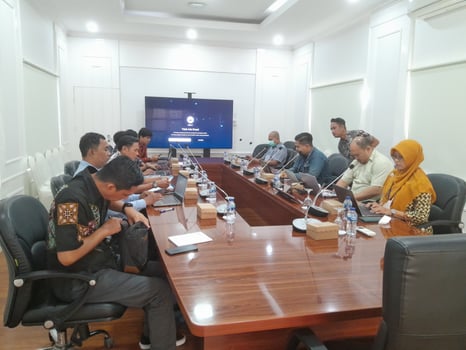 A group photo of people meeting in an office meeting room.