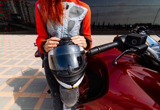 Woman Enjoying a Ride on Her Motorcycle. A woman sitting on a motorcycle with a helmet on photo