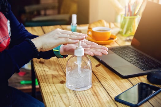 Women using laptop working clean hands with alcohol and drink coffee cup hot in the morning photo
