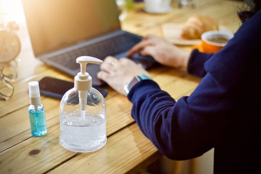 Women using laptop working clean hands with alcohol and drink coffee cup hot in the morning photo