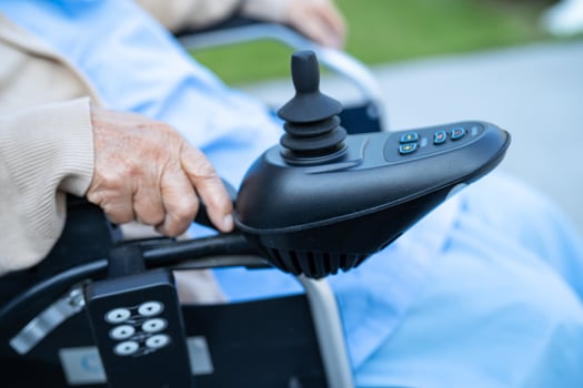 Asian senior woman patient on electric wheelchair with joystick and remote control at hospital. photo