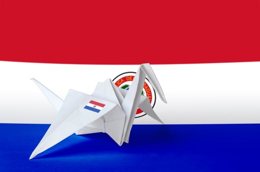Paraguay flag depicted on paper origami crane wing. Handmade arts concept photo
