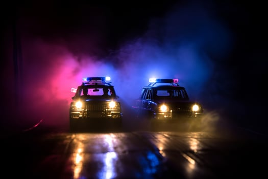 AI generated Police car chasing a car at night with fog background. 911 Emergency response police car speeding to scene of crime. Selective focus photo