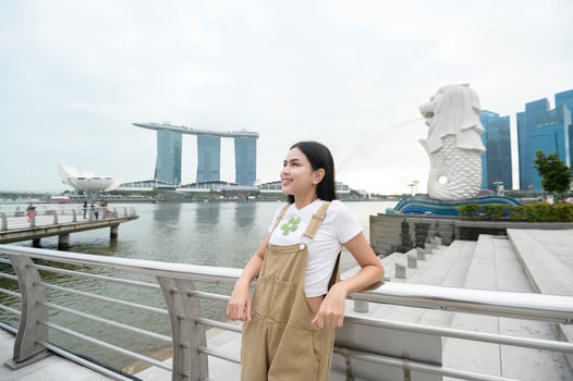 a woman in Merlion fountain in front of the Marina Bay photo