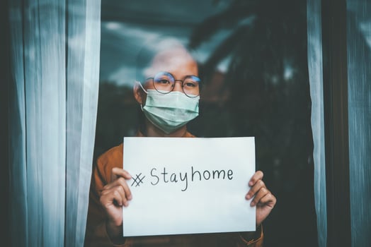 Asian girl wearing glasses, wearing a mask, holding paper labeled stayhome, is bored of having to detain and treat the illness at home alone. Concept home quarantine, prevention COVID-19 photo