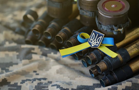 Ukrainian symbol on machine gun belt lies on ukrainian pixeled military camouflage photo