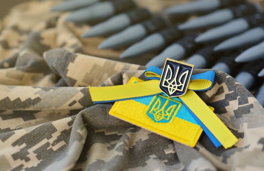 Ukrainian symbol and a machine gun belt on the camouflage uniform of a Ukrainian soldier. The Concept of war in Ukraine, patriotism and protecting your country from occupiers photo
