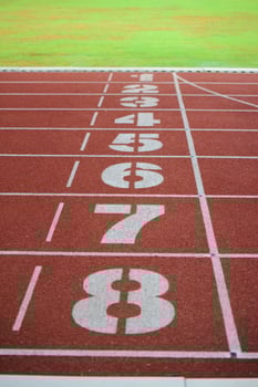 Athlete running track with number on the start . Perspective photo