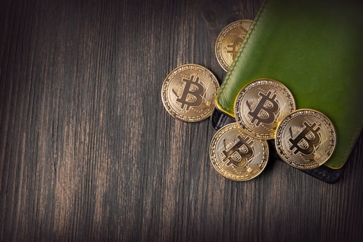 Popular cryptocurrency in leather wallet on wooden table photo