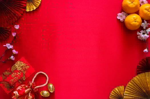 Chinese new year concept with red envelope packets or ang bao word mean auspice, red bag, ingots word mean wealth and oranges on red cloth background. photo