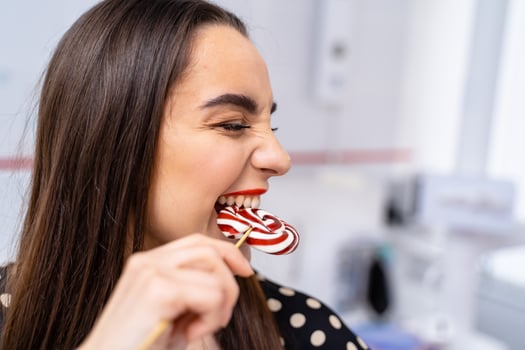 A Playful Woman Enjoying a Candy Cane. A woman holding a candy cane in her mouth photo
