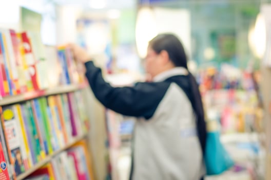 focused Blur image of a bookstore with customers reading and looking for books. Bookstore background. photo