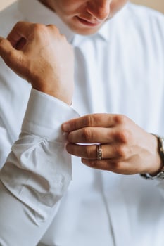 Morning of the groom and details, white shirt, good light, young man, stylish groom getting dressed, getting ready for the wedding ceremony. close-up of male hands photo
