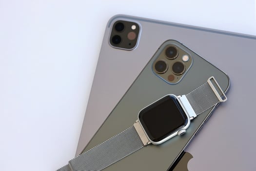KYIV, UKRAINE - 4 MAY, 2023 Apple brand devices iphone, ipad with apple watch lies on macbook body photo