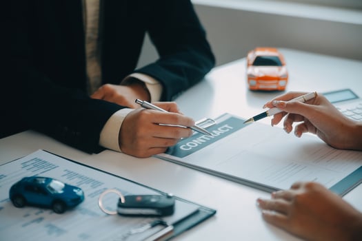 Closeup asian male people car salesman or sales manager offers to sell a car and explains and reads the terms of signing a car contract and insurance. photo