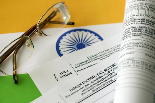 KYIV, UKRAINE - MAY 4, 2022 Indian income tax return blank form with pen and indian rupees bills photo