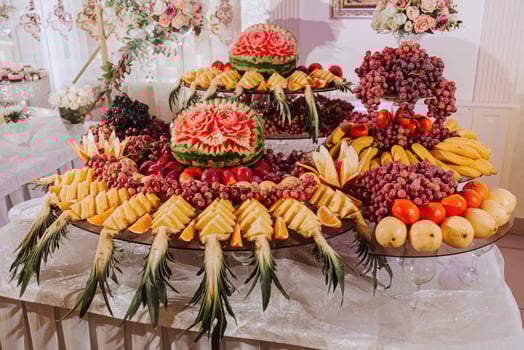 table with various fruit decorations. Watermelon carving, pineapple slices, grapes, orange photo