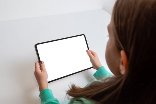 Girl watching a movie on a tablet in a horizontal position at her work desk. Isolated screen for multimedia promotion photo