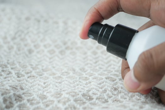men uses stain remover spray for office shirt photo
