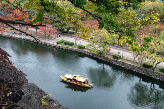 Golden ancient boat sailing on river in autumn garden photo