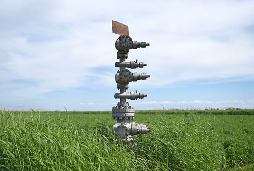 Canned oil well against the sky and field photo