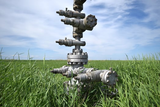 Canned oil well against the sky and field photo