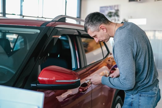 A man examines a car in the cabin for defects. Car rent. Buying a car photo