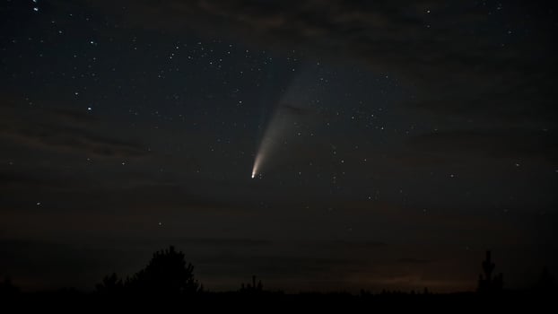 Comet NEOWISE moves across the night sky among the stars photo