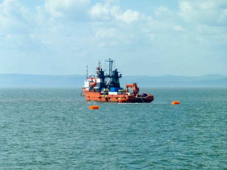 A small service ship in a cargo industrial port. A ship in the sea photo