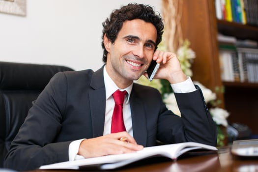 Cheerful man in office answering the phone photo