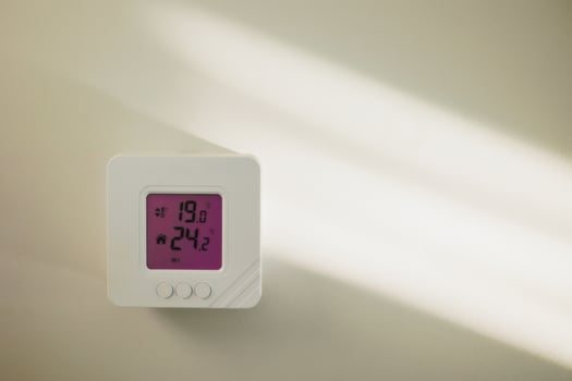 Close-up shot mounted on white wall, climate control showing 24.2 degrees indoors, remote air conditioner inside smart home close-up, no people. Modern technologies, the concept of a comfortable life photo