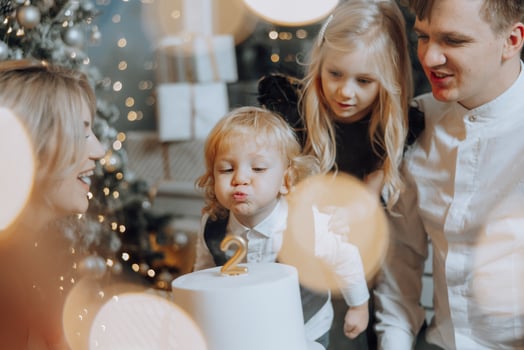 Cheerful and happy family with Christmas gifts celebrating birthday for two years. Children are having fun. Loving family with gifts in the room. photo