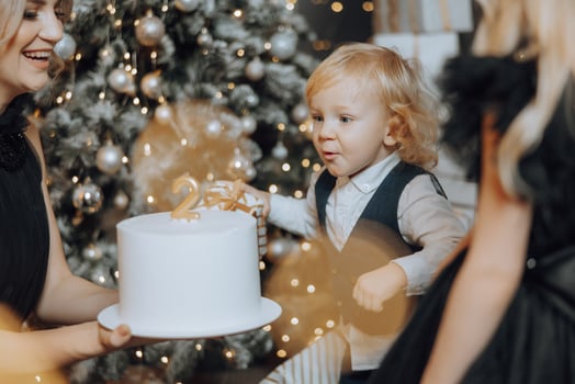 Cheerful and happy family with Christmas gifts celebrating birthday for two years. Children are having fun. Loving family with gifts in the room. photo