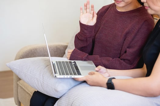 Relaxed young Asian woman enjoying relaxation on a comfy sofa at home. The beautiful girl calmly relaxes and breathes fresh air in the house. Watch movies and social networks. photo