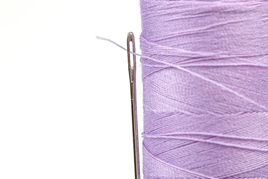 Macro skein of thread purple colors with a needle on a white background photo