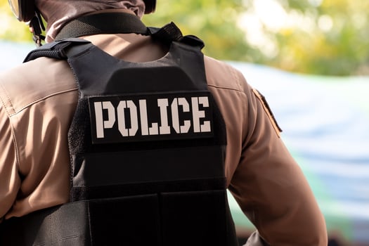 Back view of male police officer dressed. A bullet proof vest on his back spells out the word police. Thailand police uniform, Protection and maintenance of peace and order photo