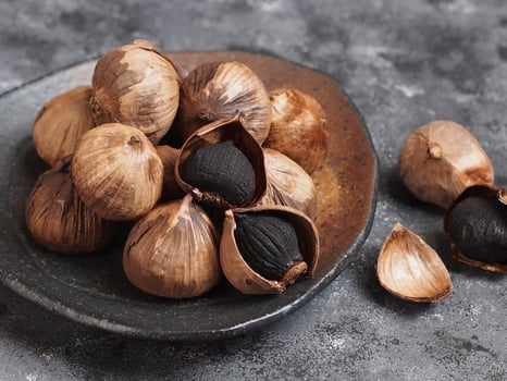 Aged black garlic, healthy food eating with high antioxidants. photo