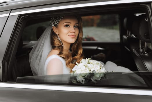 close-up portrait of a pretty shy bride in a car window photo