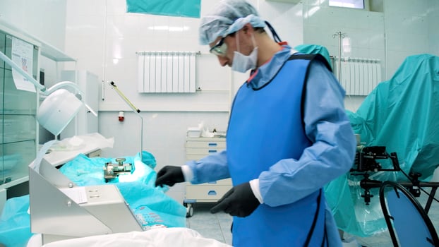 Doctor 's office . Creative . A beautiful spacious room where you can see a man in uniform with glasses for work who performs operations and moves medical devices. photo