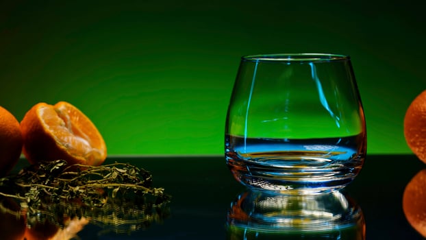 Close up of empty cocktail glass with rosemary and oranges on the bar counter. Stock clip. Concept of gastronomy and cuisine. photo